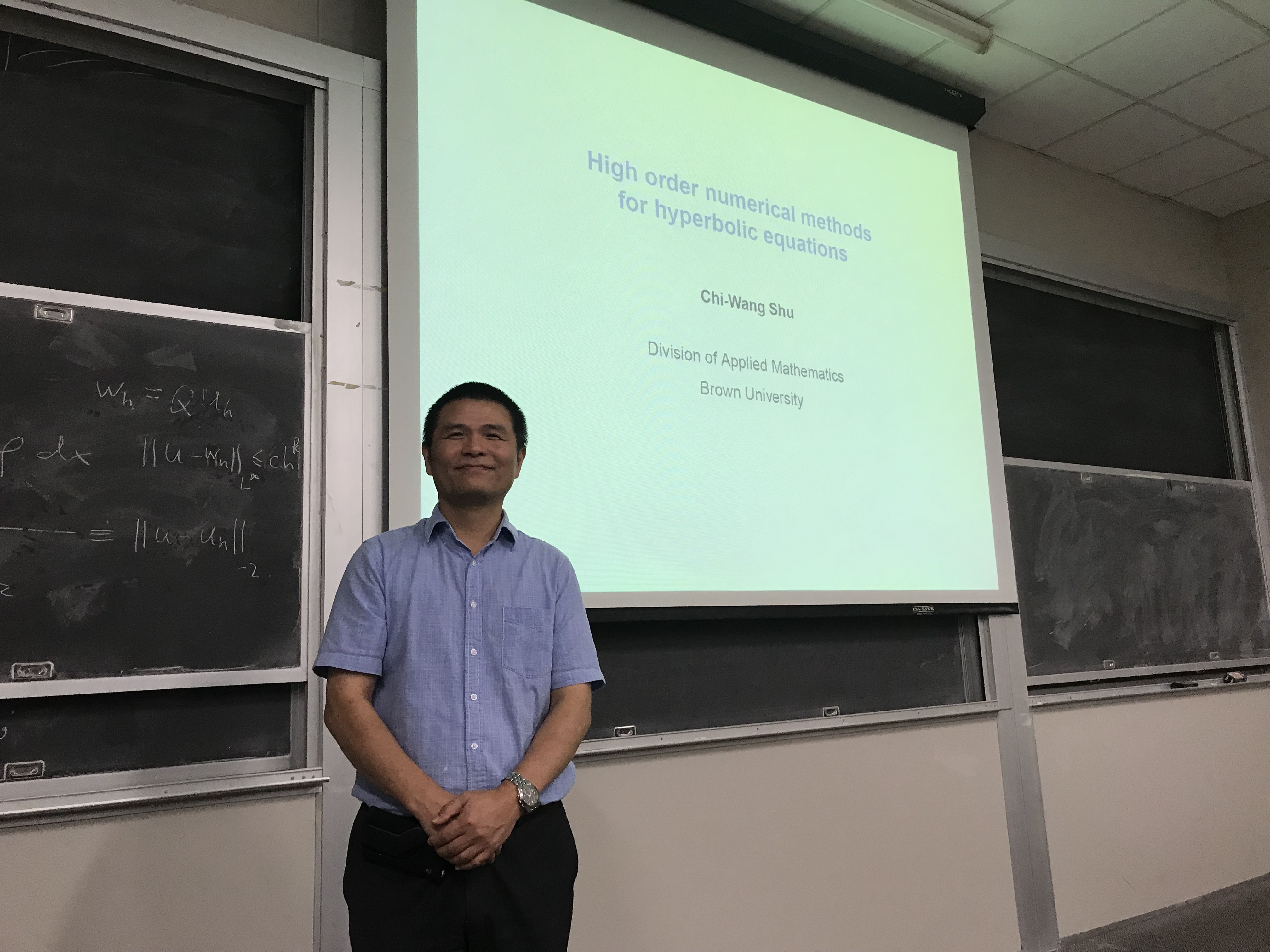 Image of professor standing in front of black board