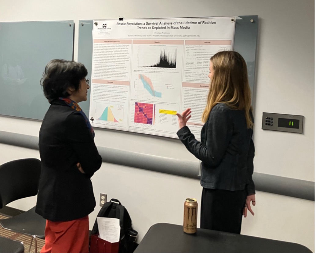 Dr. Ji-Hyun Lee discusses research with an undergraduate student researcher during the student poster session.